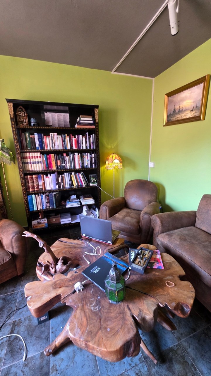 The Vallico Academy living room with armchairs, a low wooden table and the Classical Education Library
